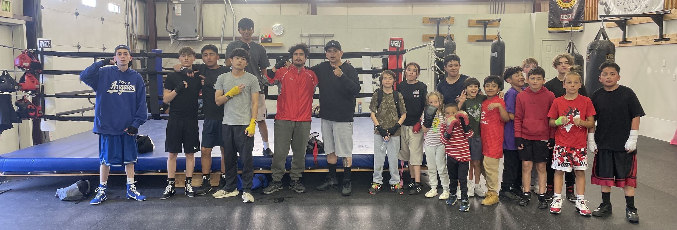 The BoxFit Utah team of kids, teens, and coaches lined up in front of the ring