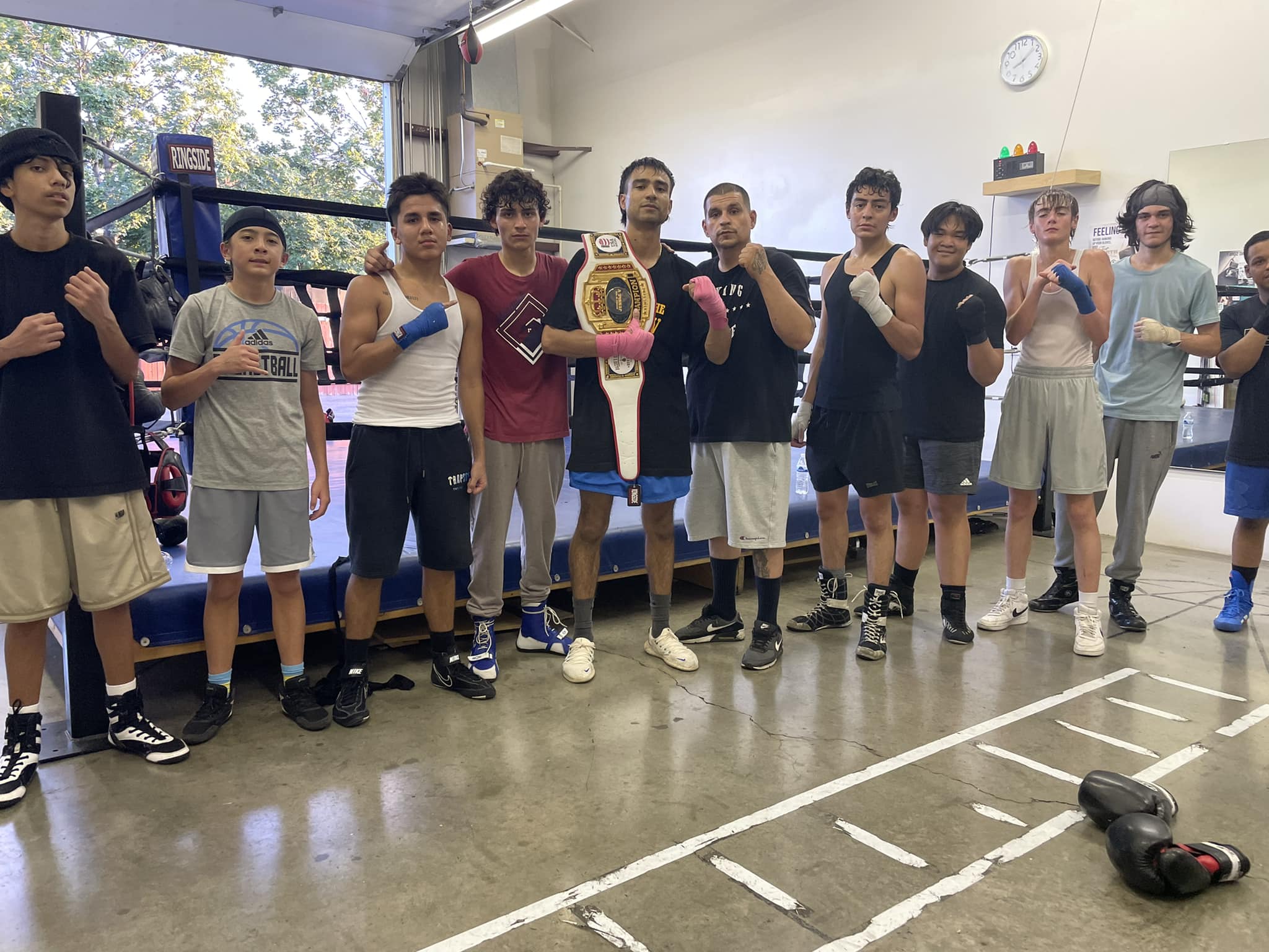 El equipo de BoxFit Utah con un cinturón de campeón en el gimnasio