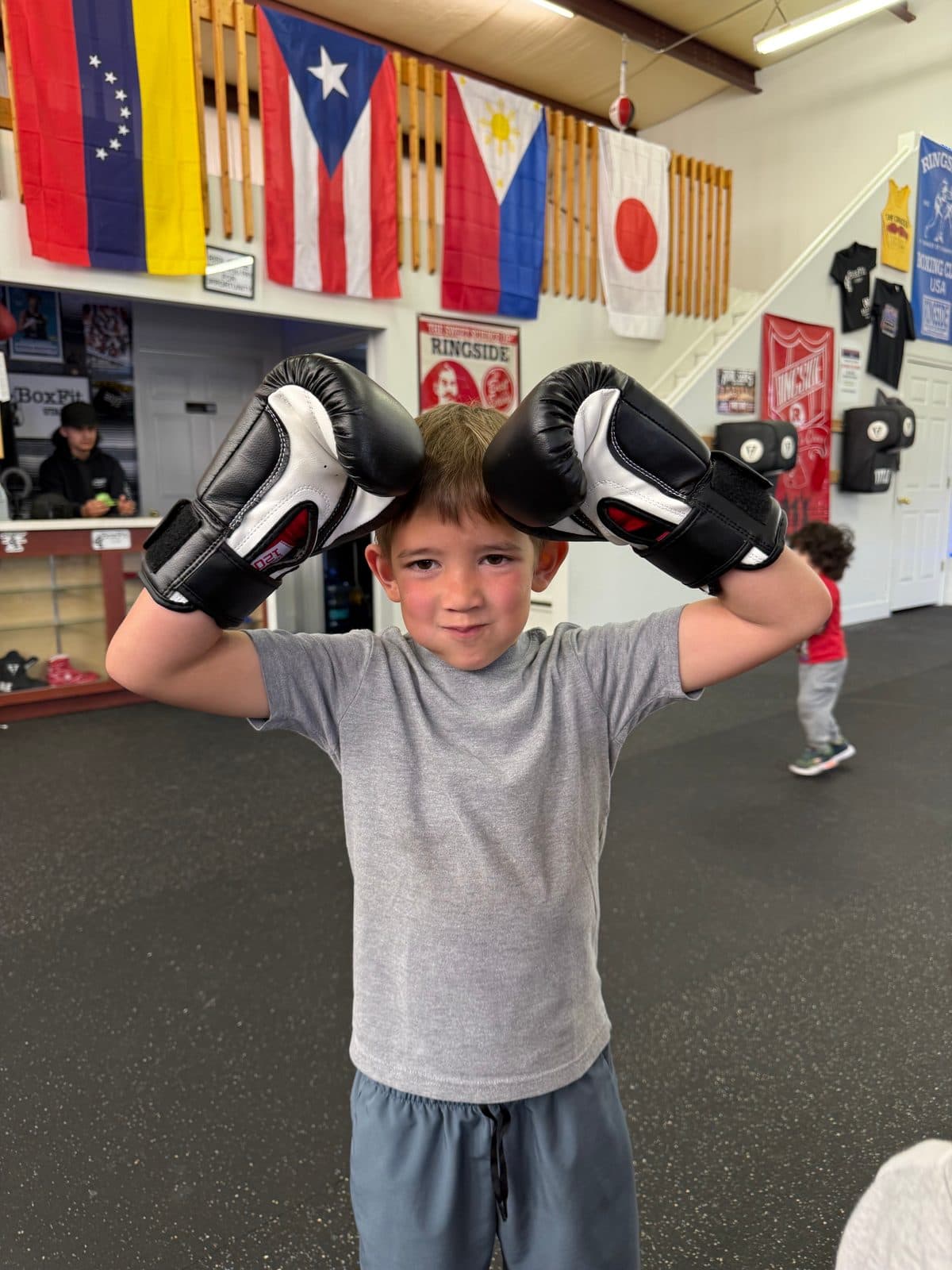 Young boxer with gloves at BoxFit Utah's kids class