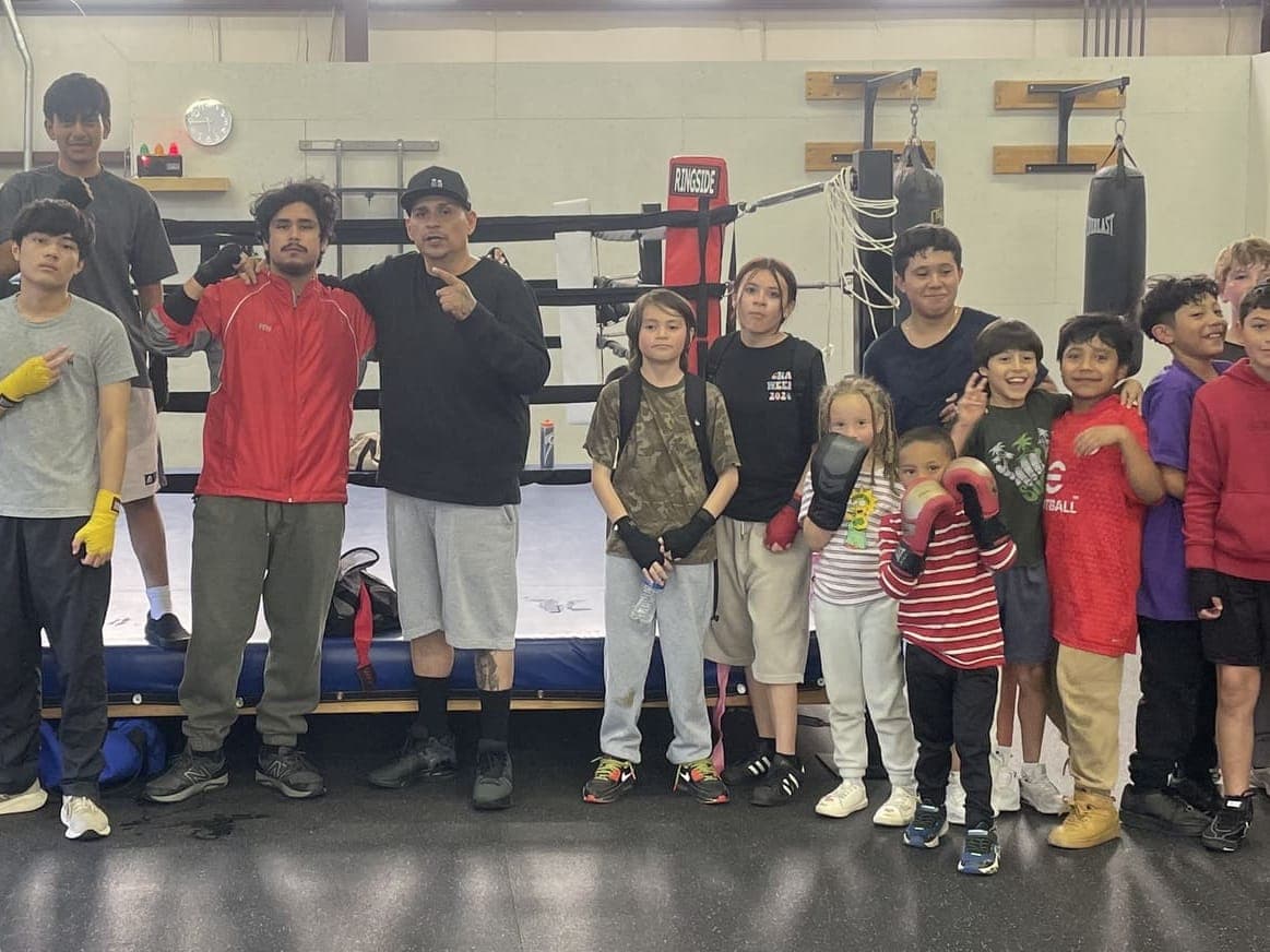 Coach Pablo with young boxers lined up in front of the ring at BoxFit Utah